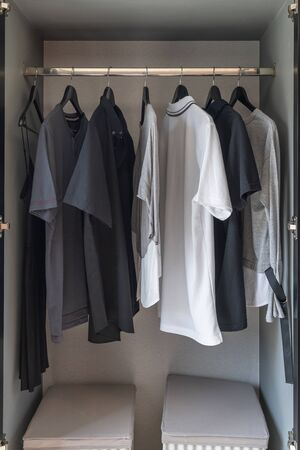 modern wardrobe with set of clothes hanging on rail, modern closet interior design conceptの写真素材