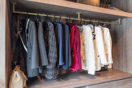 modern wardorbe with set of clothes hanging on rail, modern closet interior design concept