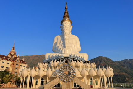 Big Buddha statue at temple on the mountains with sunshine and blue skyの写真素材