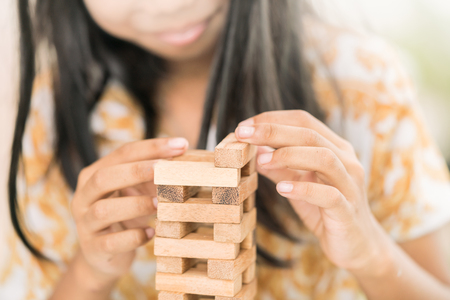 Girl's hand holding/playing wooden block, challenge in business, education background conceptの写真素材