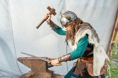 Strong viking is repairing his swordの写真素材