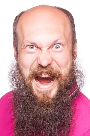 Unleashed emotions. Frustrated young man with blue opened eyes and mouth opened while standing looking at camera, isolated on white background.の写真素材