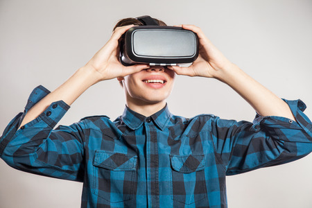 Emotional funny man wearing virtual reality goggles. Studio portrait of video game designer wearing...