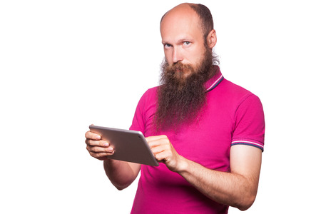 portrait of bald bearded man with tablet and pink t-shirt isolated on white background.の写真素材