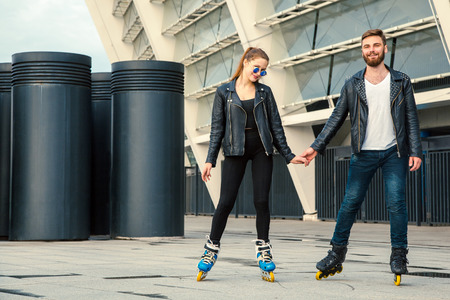 Beautiful roller skater couple with hipster style skating after the rain.の写真素材