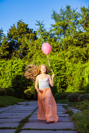 Beautiful girl with balloon have a fun in the park.の写真素材