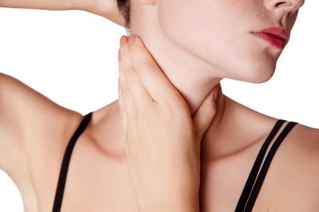 Closeup view of a young woman with pain on neck or thyroid gland.の素材 [FY31069033440]