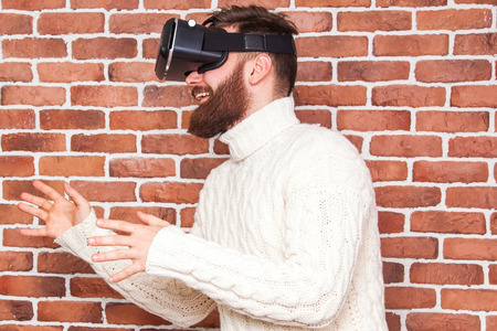 VR headset technology and man at home near brown wall.