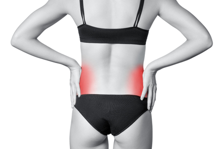 Closeup view of a young woman with pain in kidneys.  isolated on white background. Black and white photo with red dot.の写真素材