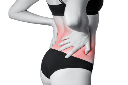 Closeup view of a young woman with pain in back.  isolated on white background. Black and white photo with red dot.の写真素材