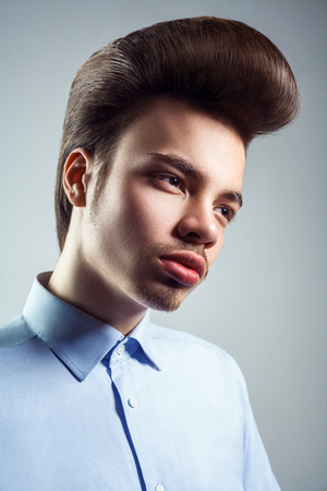 Side view of young man with retro classic pompadour hairstyle. studio shot.の写真素材