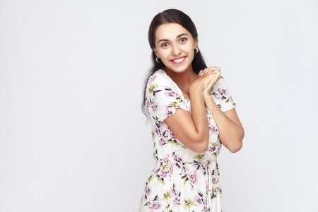 Cute and happiness woman in flowers dress, looking at camera and toothy smile. Studio shot, gray backgroundの写真素材
