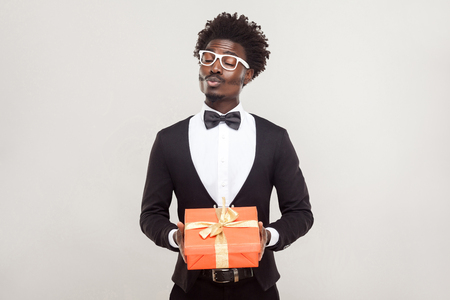Love, kiss,celebration concept. Romantic man send kiss at camera and holding gifts. Studio shotの写真素材