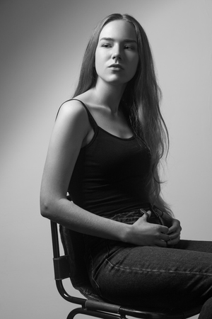 Portrait of proud  woman, looking looking at camera. Studio shot, isolated on gray backgroundの写真素材