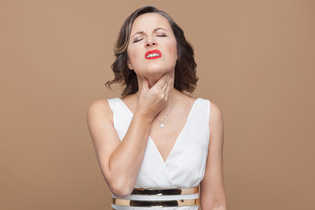 Adult woman have throat pain. Emotion and feeling concept. Studio shot, indoor, isolated on light...