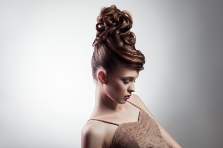 portrait of attractive brunette woman with stylish hairdo and makeup posing with closed eyes on isolated grey background. indoor, studio shot on copy space.の写真素材