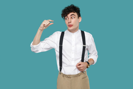 I need more. man showing a little bit gesture with finger. Portrait of handsome hipster curly young...
