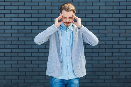 Headache, thinking or confusion. Portrait of sad or worry handsome young blonde man in casual style...