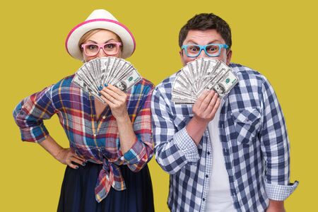 Couple of funny friends, adult man and woman in casual checkered shirt standing together holding,...