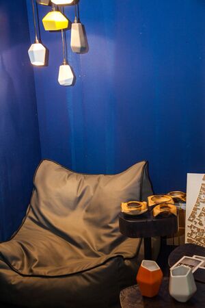grey cozy sack chair with decorative interior elements near blue wall
