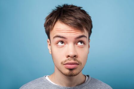 What's with my hair. Closeup portrait of young brunette man with small beard and mustache in casual...