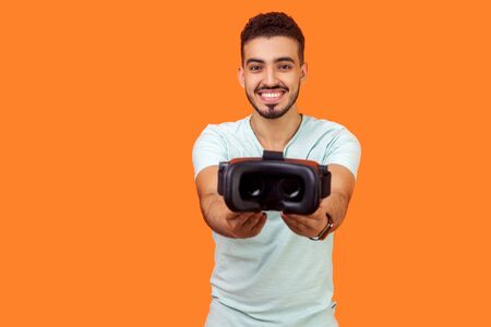 Cyberspace and innovative technologies. Portrait of cheerful brunette man in white t-shirt giving...