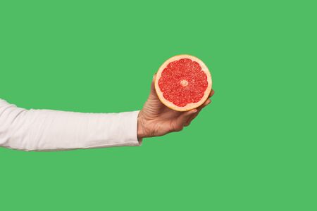 Closeup of hand holding sliced juicy grapefruit, tasty fruit for detox, natural organic vegetarian...