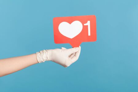 Profile side view closeup of human hand in white surgical gloves holding social media like stick....