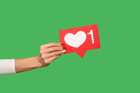 Love interesting content. Closeup of hand holding Heart Like icon of social media, emoji...