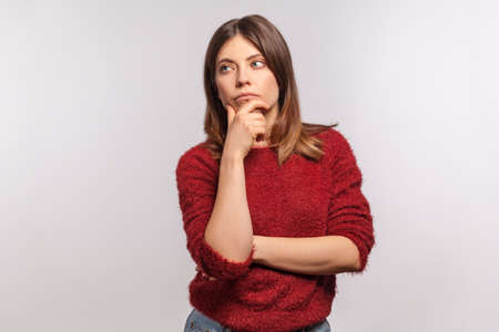 Depressed ill woman frowning and clasping sore head, suffering intense headache, having unbearable migraine, fever and flu symptoms, medial concept . indoor studio shot isolated on gray backgroundの写真素材