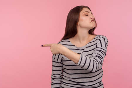 Portrait of optimistic happy woman in striped sweatshirt showing double victory gesture, peace hand sign, celebrating victory, glad about success. indoor studio shot isolated on pink backgroundの写真素材