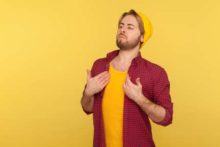 Profile of confident calm handsome man with neat hair and beard wearing sweatshirt standing, looking to side copy space with serious attentive face expression. studio shot isolated on gray backgroundの写真素材