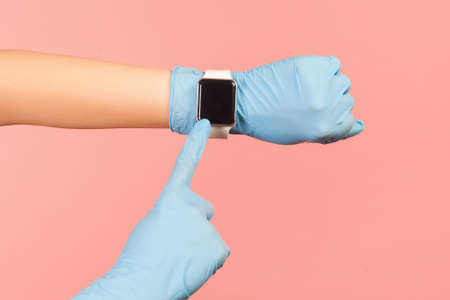 Profile side view closeup of human hand in blue surgical gloves holding and showing wirst smart...