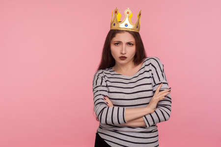 I'm queen! Portrait of egoistic haughty woman with golden crown on head crossing hands and looking...