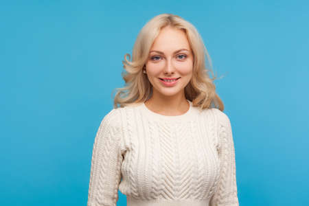 Attractive woman with blond curly hair looking at camera with toothy smile, full of energy and...