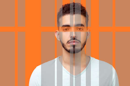 Closeup portrait of serious man with beard standing and looking focused and confident at camera. special striped lines designed and looking different. indoor studio shot isolated on orange backgroundの写真素材