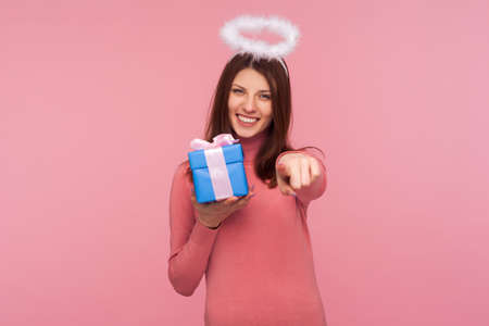 Happy birthday to you! Angelic brunette woman with nimbus over head giving present and pointing...