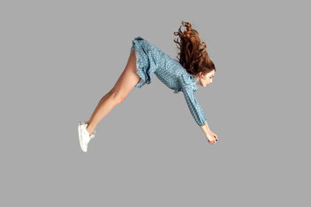 Side view girl rushing at full speed accelerate, steering driving fast and levitating in air. Model...