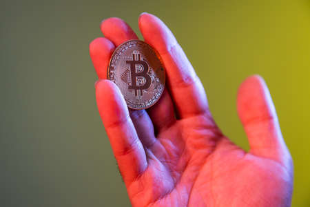 Closeup of hand holding bitcoin, advertising btc coin, copy space for cryptocurrency commercial,...