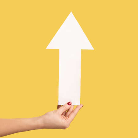 Closeup profile side view of woman hand holding arrow pointing up, growth and increase concept....