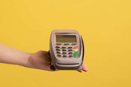 Profile side view closeup of woman hand holding and showing POS or terminal payment or pay pass...