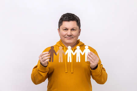Portrait of dark haired middle aged man holding paper chain of people, population, race and...