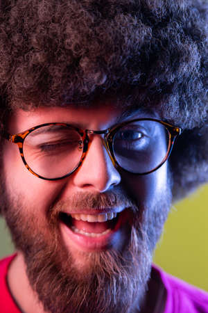Closeup portrait of positive hipster man with Afro hairstyle in good mood, smiling broadly and...