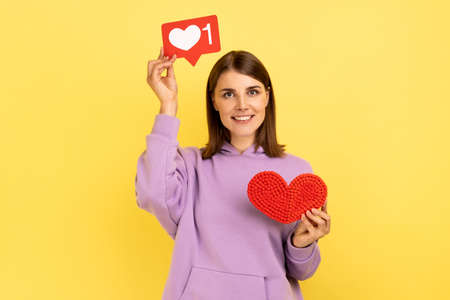 Like button of social media. Portrait of pretty woman holding like icon and red heart, recommending...