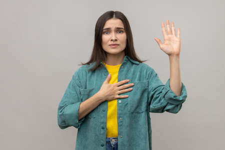 Serious patriotic woman holding hand on heart, juryman swearing to speak truth in court, honor and...