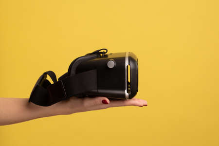 Side view of woman hand holding VR goggles, virtual reality 3d glasses headset for cyberspace...