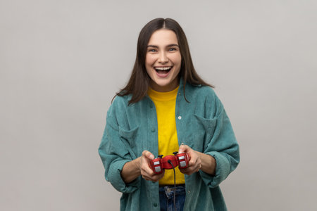 Excited woman holding gamepad, winning video games competition, looking at camera with happy...