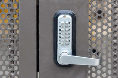 Locked private metal security gate door with push button combination lock system keypad with...