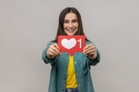 Satisfied woman holding out heart icon, recommending to follow and share blog with interesting...