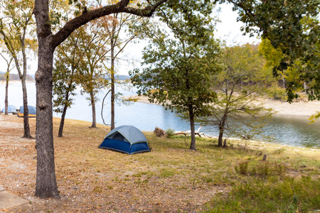 Camping tents near a beautiful lake among trees, campsite, adventure vacation concept, Broken bow lake in Oklahoma, USA.の写真素材